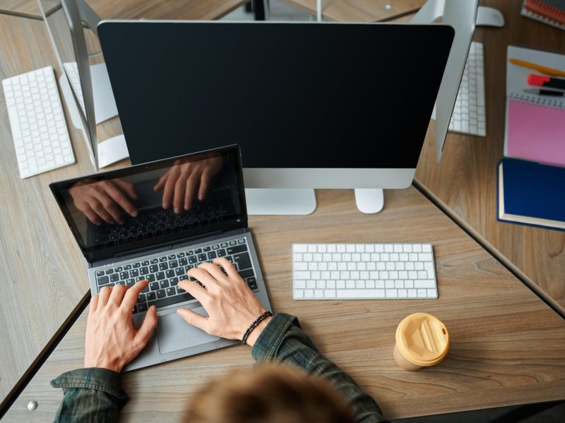 it-specialist-works-on-laptop-in-office-top-view-2021-08-30-19-00-26-utc-min