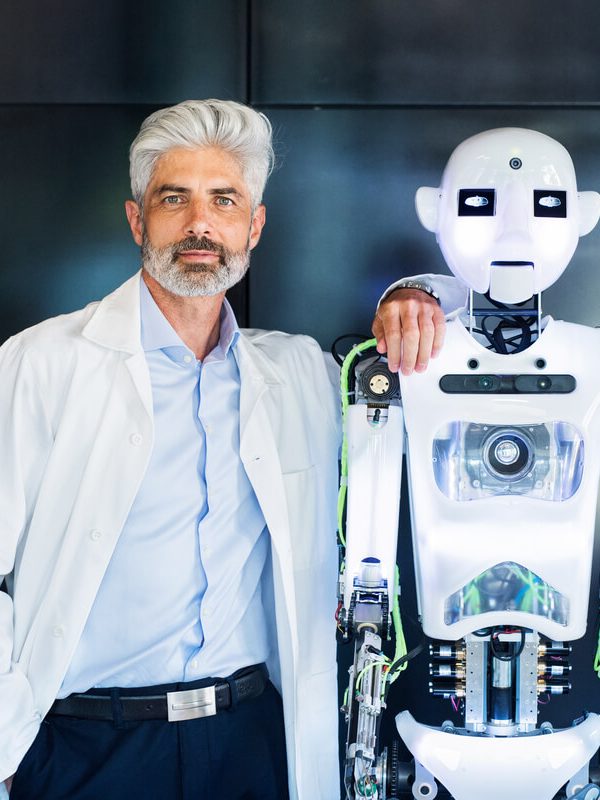mature-businessman-or-a-scientist-with-robot-PYNT5LJ